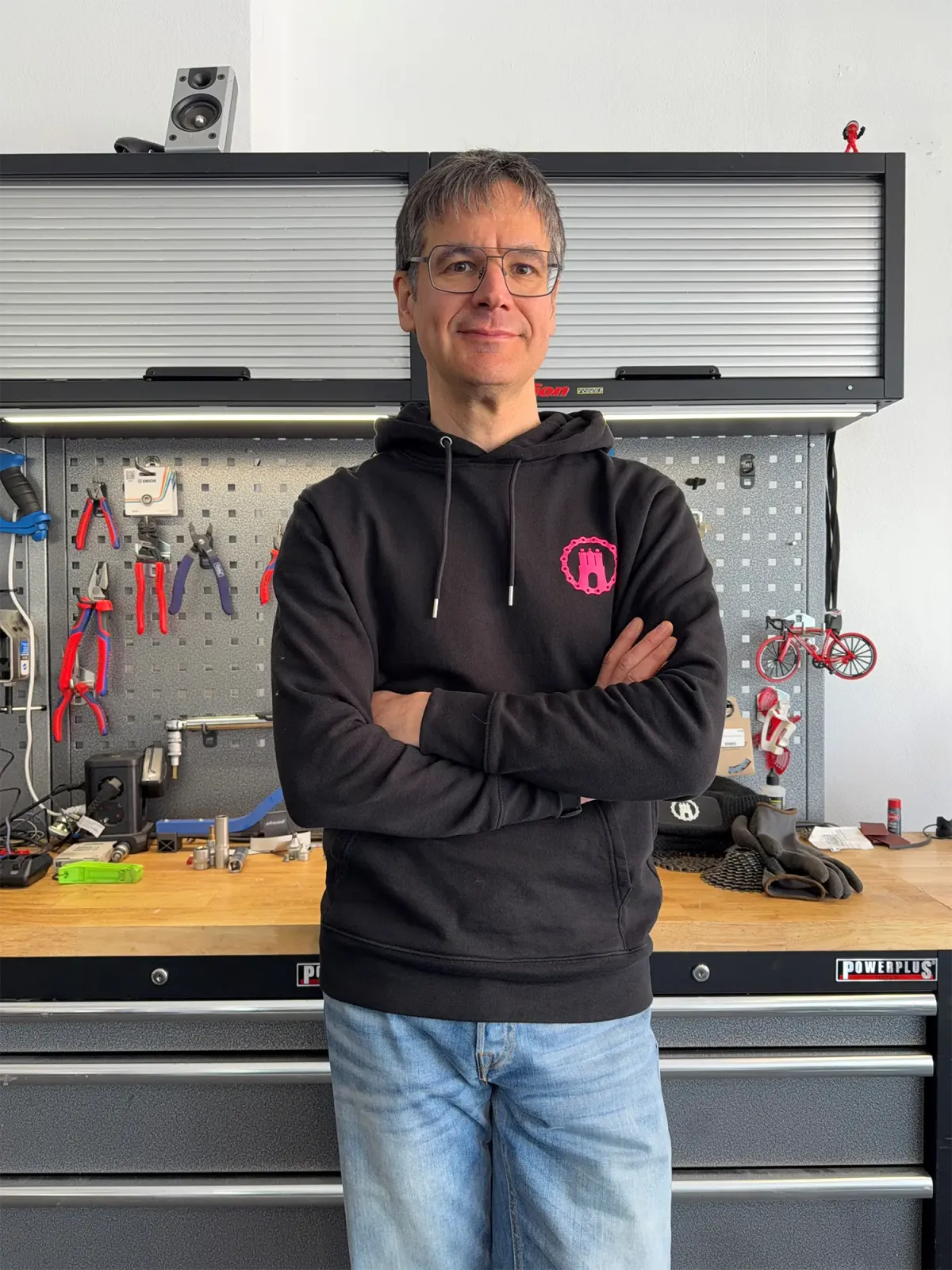 An employee stands in front of a workbench with tools.